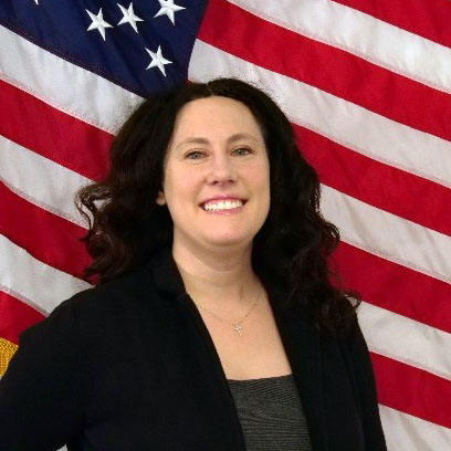 A person smiling in front of a flag AI-generated content may be incorrect.